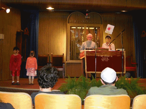 Series of photos showing the reading of the Megilah, playing games, watching Purim videos, and eating and drinking kosher food and beer.